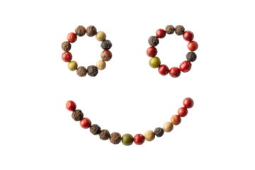 A smiley face creatively crafted using colorful peppercorns against a green backdrop. background removed