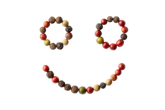 A smiley face creatively crafted using colorful peppercorns against a green backdrop. background removed