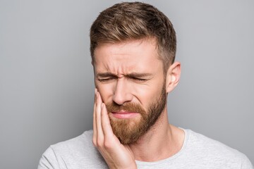Fototapeta premium Toothache and dental care young man gripping cheek in distress from severe pain
