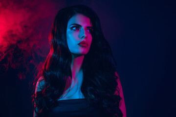 Glamorous brunette woman in vibrant neon lighting posing gracefully with intense expressions