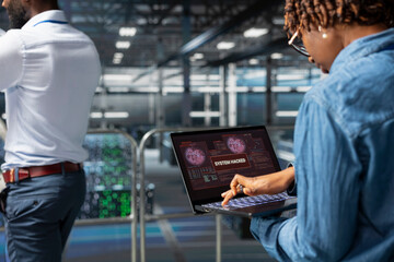 Stressed panicked woman handling cybercriminal threat response, trying to save data center sever rigs during security breach. Worried engineer reads a critical error alert on laptop.