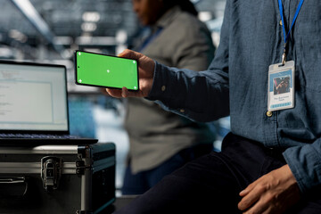Close up of server room admin using chroma key phone, watching videos during break. Data center staff member using isolated screen smartphone during during downtime at work