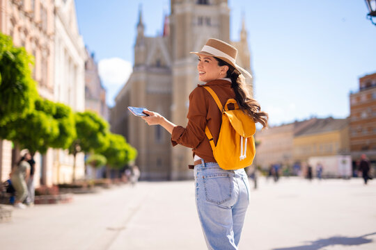 Young woman tourist exploring city with smartphone