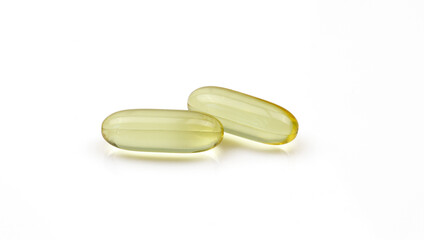 two golden gel capsule isolated on white background. oil pills dose
