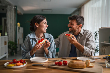 Happy couple enjoying healthy breakfast together at home