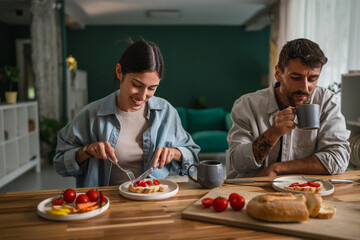 Happy couple enjoying healthy breakfast together at home