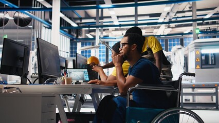 African american wheelchair user testing CAD software for manufacturing solar panels, factory engineer working in solar energy industry. Specialist with disability at the job. Camera B.