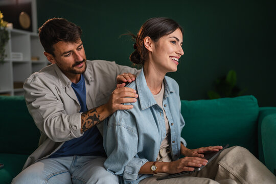 Partner giving relaxing neck massage to woman using tablet - Powered by Adobe