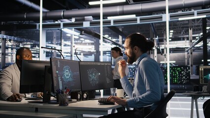 Data center system administrator talking with coworker in office while doing software updates....