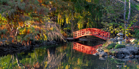 Panoramic view of red bridge in Japanese park with in Cranbrook gardens in Troy, Michigan in autumn time.
