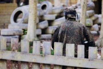 Paintball game, team in camouflage protective uniform with paintball guns and ammunition, strikeball arena battlefield, paintballer aiming and shooting at opponents, airsoft players match tournament