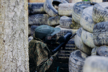 Paintball game, team in camouflage protective uniform with paintball guns and ammunition, strikeball arena battlefield, paintballer aiming and shooting at opponents, airsoft players match tournament