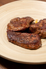 Close-Up of Spice-Seasoned Steak Served on a Wooden Plate with Chopsticks
