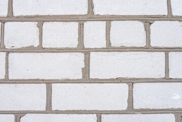 Light gray brick wall texture. Close-up of masonry surface with horizontal lines and concrete joints. Rough-textured surface of masonry with visible cement seams