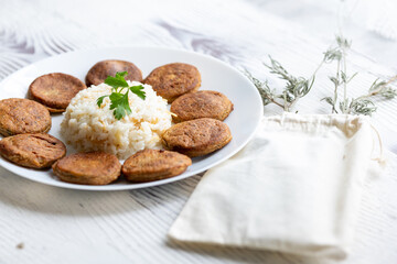 Close-Up of Kotlety Mielone Meatballs with Greens on a White Plate
