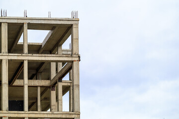 Unfinished concrete building structure against cloudy sky