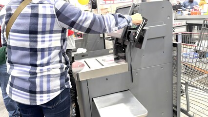 Customers pay using self-service scanners in supermarkets.
