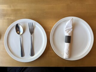 Dining Setup with Spoon and Fork Beside Napkin on White Plates