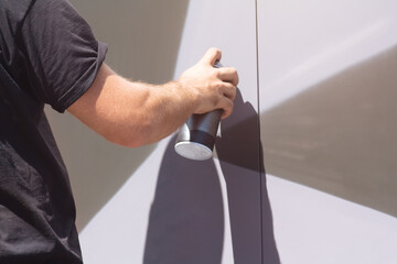 Man doing graffiti, holding spray can with hand. Spray aerosol paint for graffiti