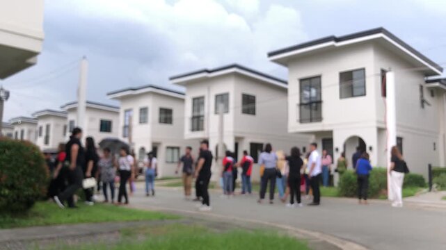 Real estate developers and brokers showcase their modern model homes in a subdivision to potential buyers. Blurs