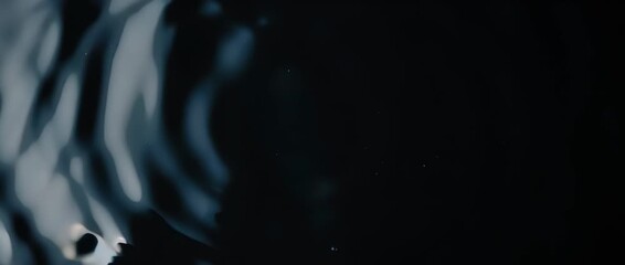 A single drop creates glowing ripples of light. A metaphor for how one action of awareness can spread and create a wave of support and change.