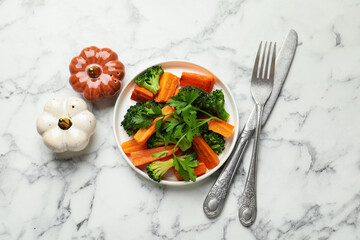 Salt, pepper shakers, vegetables, parsley and cutlery on white marble table, flat lay