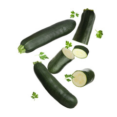 Fresh zucchini and parsley falling against white background