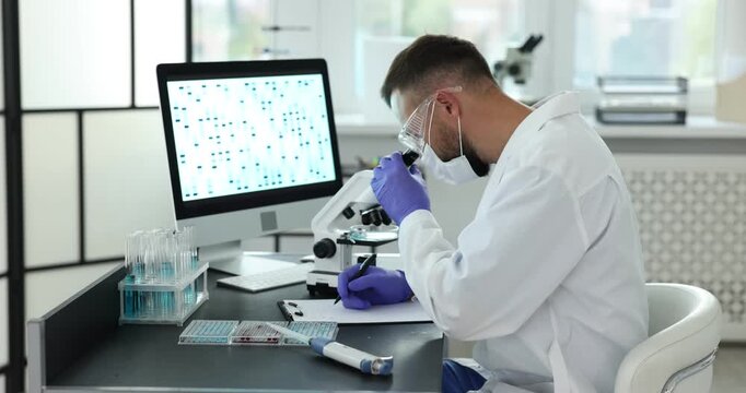 Research in genetics. Scientist working with microscope at table in laboratory