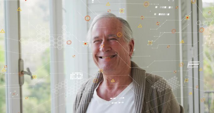 Senior man beside window smiling as orange graphics materializing across torso in tech demo