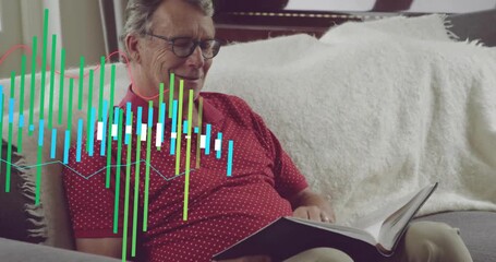 Senior man picking book on sofa, activating green data bars for tech demo, reading for insight - Powered by Adobe