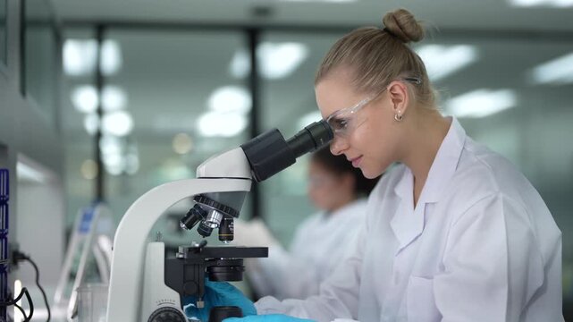 A pathologist performs real-time annotation, looking at a tissue biopsy under the microscope while using a stylus and tablet to digitally circle and document abnormal cells for her report.