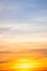 Sunset or sunrise sky with a vibrant gradient of orange, gold, and soft blue. Clear atmosphere with wispy clouds. Peaceful, natural light background. hope, freedom, new day Concepts, Vertical