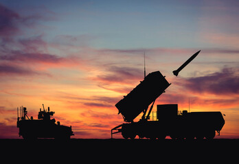 Silhouette of a MIM-104 Patriot American anti-aircraft missile system against the backdrop of sunset. Air defense. Illustration for design on the theme of military defense and military technology.