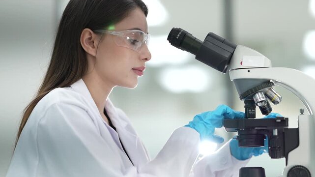 A pathologist in a hospital lab examines a stained tissue specimen under a microscope, identifying cellular abnormalities to provide a definitive diagnosis for a patient's condition.