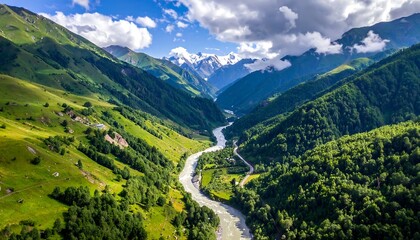 High-angle view of a picturesque valley nestled between verdant hills and snow-capped mountains, showcasing a winding river snaking through the landscape.