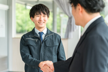 握手をする作業着姿の男性ビジネスマン,作業員
