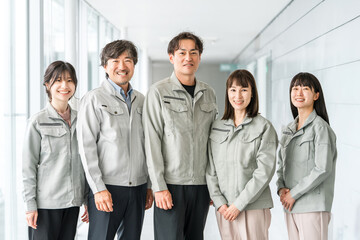 Obraz premium Male and female staff in the manufacturing, building, transportation and construction industries wearing work clothes 