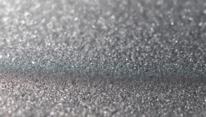 Abstract sparkling silver glitter texture background. Close-up of shimmering grey granular surface with light reflections.