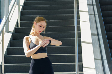 Fit sport woman, outdoor exercise workout stretch, inspires people. She checks fitness tracker,...