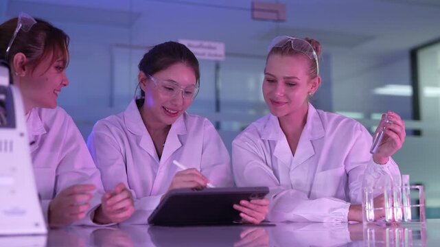 In a cosmetic science lab, researchers analyze a new liquid formulation in a test tube and review its performance data on a tablet during the product development phase.