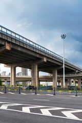 Fototapeta premium Concrete structure and asphalt road space under the overpass in the city