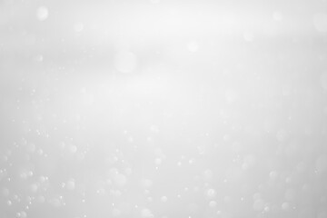 blurred white glitter vintage lights background. white bokeh shiny on dark background.