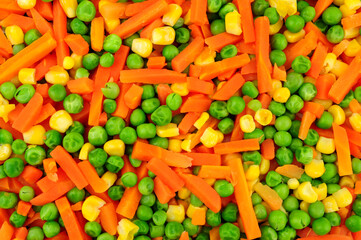 Cooked mixed vegetable background detail including carrots, peas and sweetcorn
