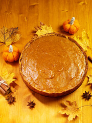 Traditional Thanksgiving pumpkin pie on a wooden table, top view