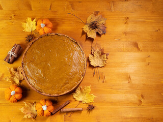 Traditional Thanksgiving pumpkin pie on a wooden table, top view copy space