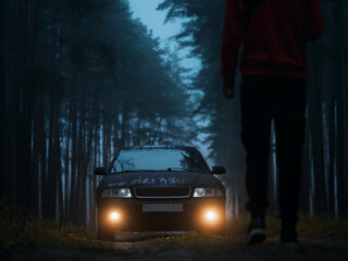 man walks to a parked car in a foggy autumn forest