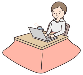 こたつでパソコン作業をする女性