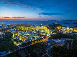 Fototapeta premium Petrochemical plant and oil refinery operating at night on the coast. Industry and energy background.