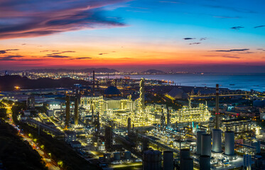 Fototapeta premium Aerial view of a large oil refinery and petrochemical plant on the coast at sunset.