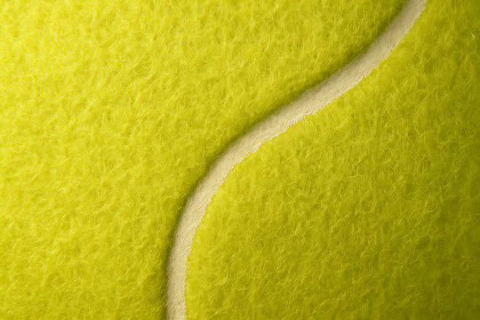 Macro close-up of yellow tennis ball texture with white line background